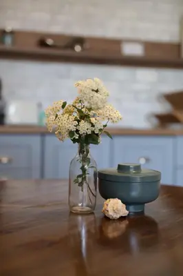 a glass vase with flowers and a bowl on a table at Guest house Dimant in Burgas City