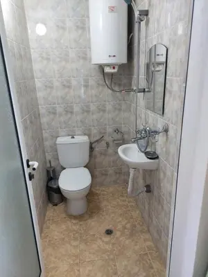 a small bathroom with a toilet and a sink at Стаи за гости WEST in Pomorie