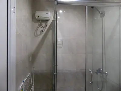 a shower stall with a glass door with a shower at Apartament HOLIDAY in Burgas City