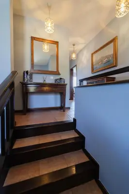 a hallway with stairs with a mirror and a vanity at Luxury 3-bedroom villa in Sozopolis with sea view in Sozopol