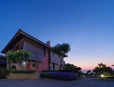 a house at dusk with the sunset in the background at Luxury 3-bedroom villa in Sozopolis with sea view in Sozopol