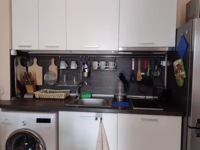 a kitchen with white cabinets and a sink and a dishwasher at Messembria Resort in Sunny Beach
