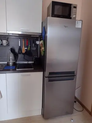 a refrigerator with a microwave on top of it in a kitchen at Messembria Resort in Sunny Beach