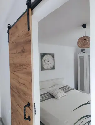a bedroom with a sliding door leading to a bed at La Veranda къща за гости Царево in Tsarevo
