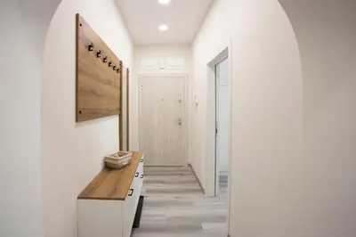 a hallway with white walls and a wooden counter at Апартамент за гости Стела in Burgas City