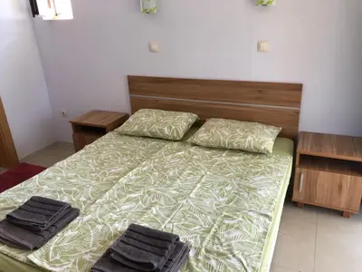a bedroom with a bed with two black towels on it at Apartment Black Sea Shark in Chernomorets