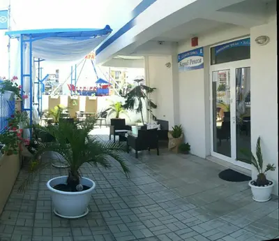 a patio with potted plants in front of a building at Семеен Хотел 
