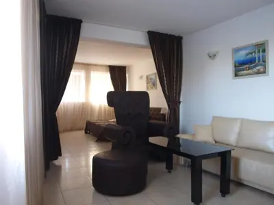 a living room with a chair and a couch at Семеен Хотел 