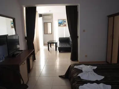 a hotel room with a dress on a bed at Семеен Хотел 