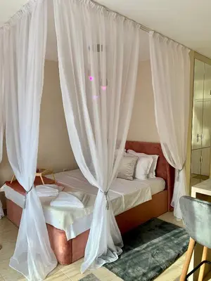 a bedroom with a canopy bed with white curtains at Beige-a-view, Sea Dreams in Sveti Vlas