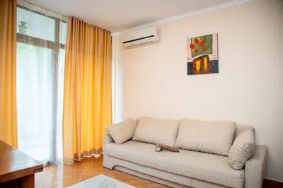 a living room with a couch in front of a window at Helios Studio in a Complex in St Vlas by Flat Mаnаger in Sveti Vlas