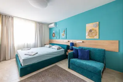 a bedroom with a bed and a chair at Turquoise in Pomorie