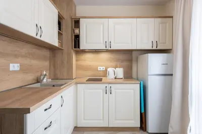 a kitchen with white cabinets and a white refrigerator at Turquoise in Pomorie