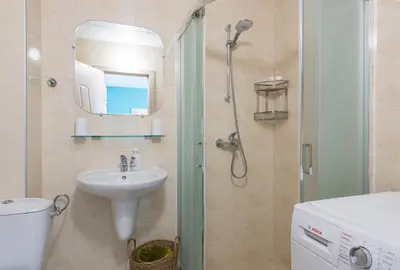 a bathroom with a sink and a shower with a mirror at Turquoise in Pomorie