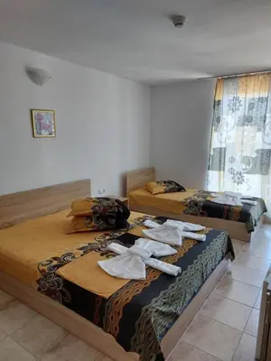 two beds in a room with towels on them at Къща за гости WEST in Sunny Beach
