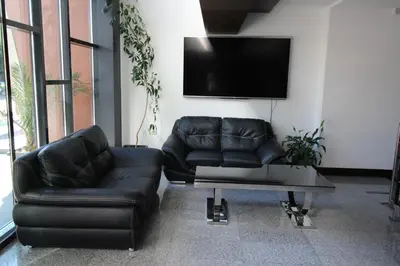 a living room with two leather couches and a tv at PARADISO 'В' 109 Large Cozy Studio NESEBAR in Nesebar