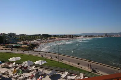 a beach with people sitting on chairs and the ocean at PARADISO 'В' 109 Large Cozy Studio NESEBAR in Nesebar