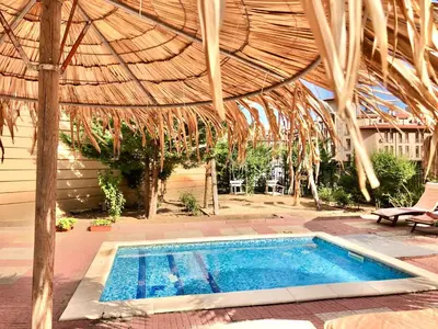 a swimming pool under a thatched roof with a swimming pool at Sunny View Central - Menada Apartments in Sunny Beach