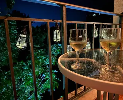 two glasses of wine sitting on a table on a balcony at Pollo Resort, Summer Wind Apartaments in Sunny Beach