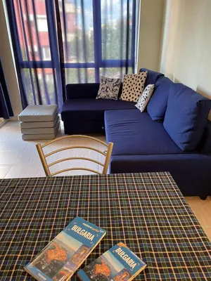 a living room with a couch and two books on a table at Pollo Resort, Summer Wind Apartaments in Sunny Beach
