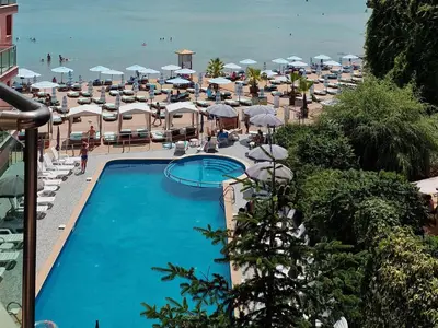 a view of a swimming pool with umbrellas and the beach at Beachfront Smart Homes by Marty's in Sunny Beach
