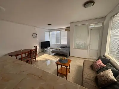 a living room with a couch and a table at Апартамент Енигма in Sveti Vlas