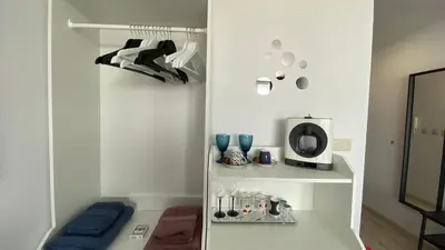 a room with white walls and a shelf with blue glasses at PARADISO 'В' 408 Private Studio Nessebar in Nesebar
