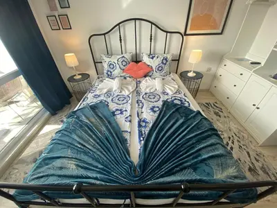 a large bed with blue and white sheets and pillows at PARADISO 'В' 408 Private Studio Nessebar in Nesebar