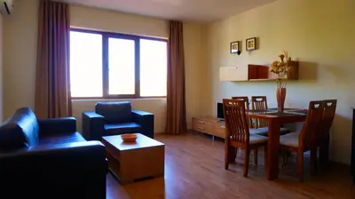 a living room with a couch and a table and chairs at Апартамент Сънрайз Обзор - Apartment Sunrise Obzor in Obzor