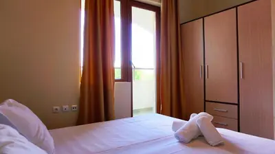a bed with a pair of white towels on it at Апартамент Сънрайз Обзор - Apartment Sunrise Obzor in Obzor