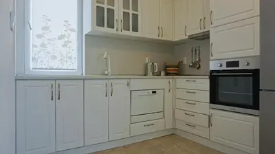 a white kitchen with white cabinets and a window at Апартаменти Атеа на плажа - Apartments Atea on the beach in Obzor