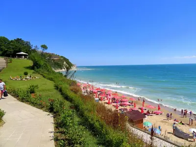 a beach with many umbrellas and people on the beach at Бяла Клиф Форест - Byala Cliff Forest in Byala