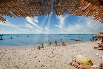 a group of people on a beach with the ocean at Fort Noks - Menada Apartments in Sveti Vlas