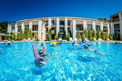 a group of people swimming in a swimming pool at Fort Noks - Menada Apartments in Sveti Vlas