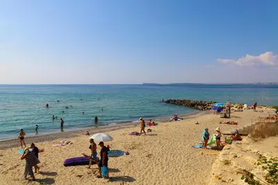 a group of people on a beach near the ocean at Fort Noks - Menada Apartments in Sveti Vlas