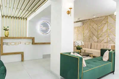 a waiting room with a green couch in the lobby at Hotel Zonya in Sunny Beach