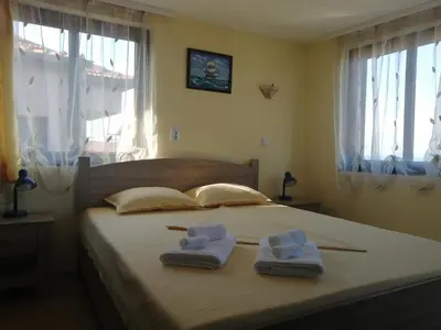 a bedroom with a bed with two towels on it at Къща за гости ЕЛЕНИ in Sozopol