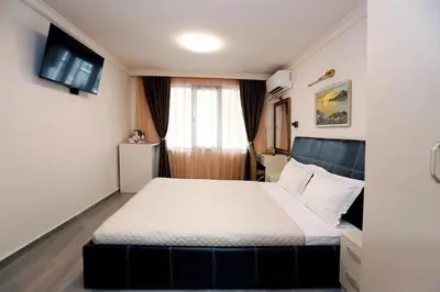 a hotel room with a bed and a window at Deluxe 2 Studios City Center in Burgas City