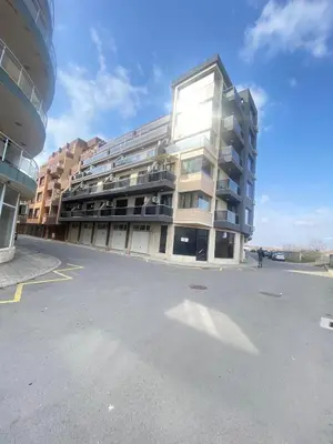 a large apartment building in a parking lot at Modern Apartment for 4 Guests Sea View & Free Parking in Pomorie
