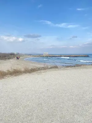 a beach with people walking on the sand and the ocean at Modern Apartment for 4 Guests Sea View & Free Parking in Pomorie