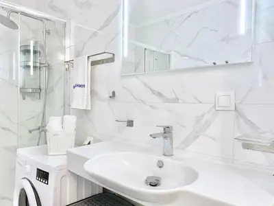a white bathroom with a sink and a mirror at Modern Apartment for 4 Guests Sea View & Free Parking in Pomorie