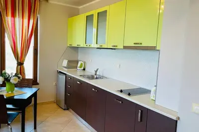 a kitchen with yellow cabinets and a sink and a table at Apartment Doris in Sunny Beach