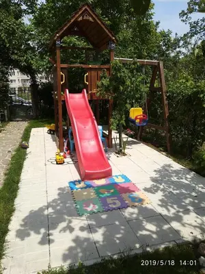 a playground with a red slide in a backyard at Акротирия Фешева in Nesebar