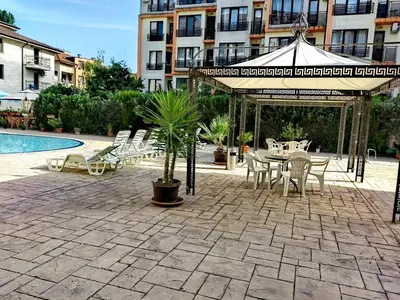 a patio with a table and chairs next to a pool at Pool Apartment Amadeus Lux in Sunny Beach
