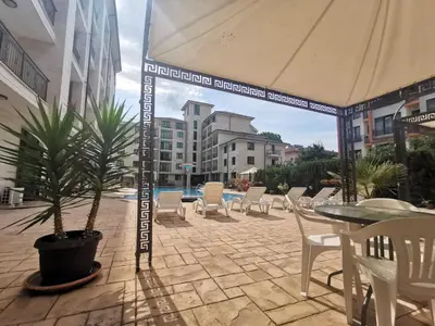 a patio with a table and chairs and an umbrella at Pool Apartment Amadeus Lux in Sunny Beach