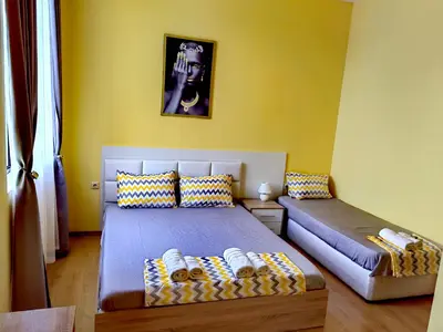 two beds in a room with yellow walls at Pool Apartment Amadeus Lux in Sunny Beach