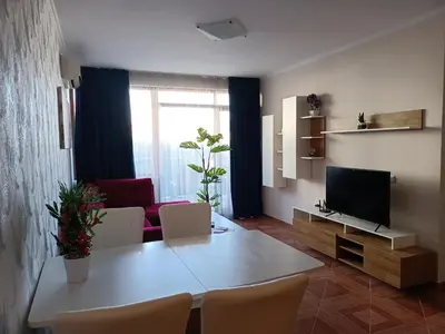 a living room with a white table and a television at Sun Wave EXCLUSIVE in Sveti Vlas
