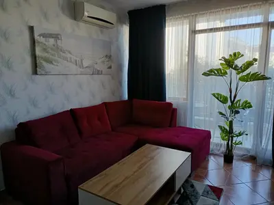a living room with a red couch and a table at Sun Wave EXCLUSIVE in Sveti Vlas