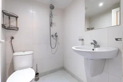 a white bathroom with a toilet and a sink at Jazz & Wine - Luxury apARTment By The Sea & Parking & HBO & Netflix in Varna City