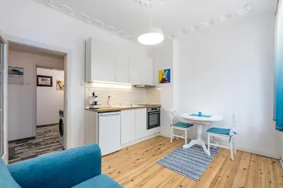 a kitchen with a blue couch and a table at Jazz & Wine - Luxury apARTment By The Sea & Parking & HBO & Netflix in Varna City